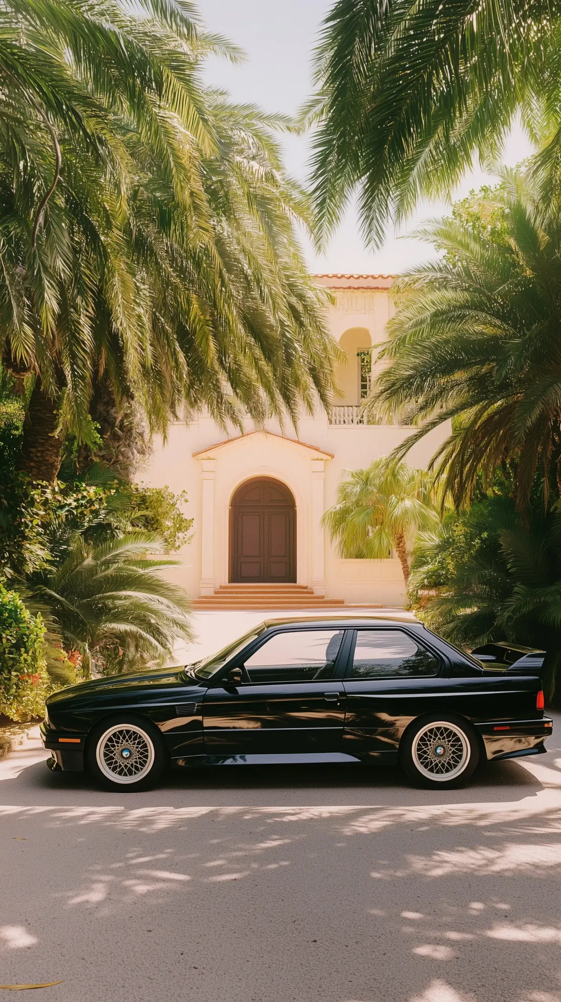 Black car parked in front of a beige residential house in a quiet suburban neighborhood.